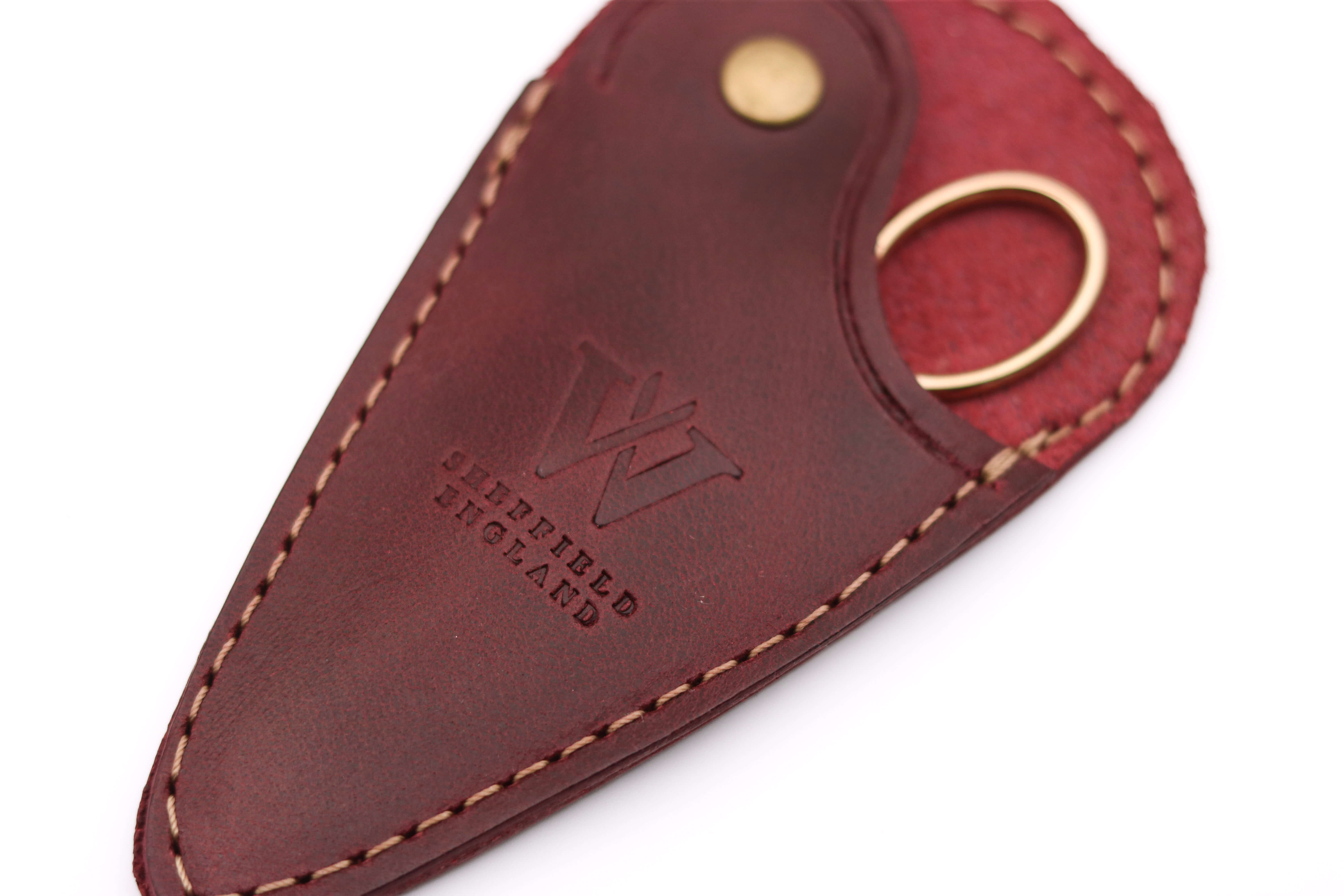 Close-up of hand-stitched detail on a Sheffield-made oxblood leather scissor sheath